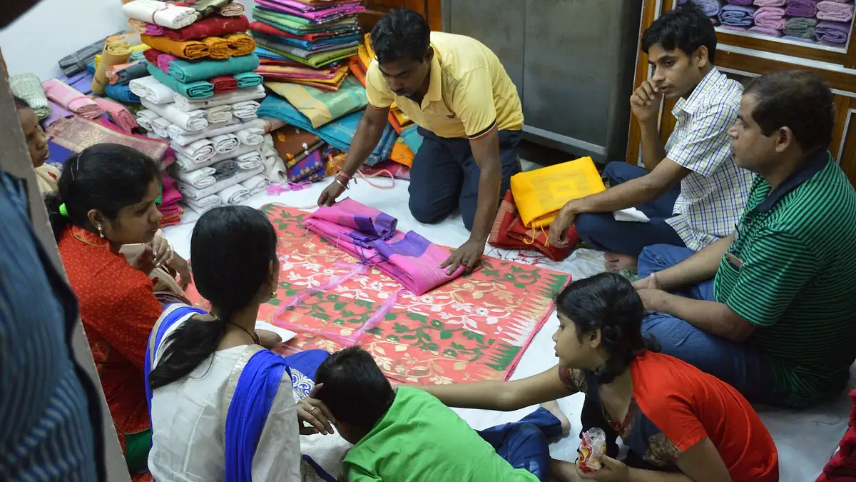 A family and shop staff choosing sarees together on the shop floor
