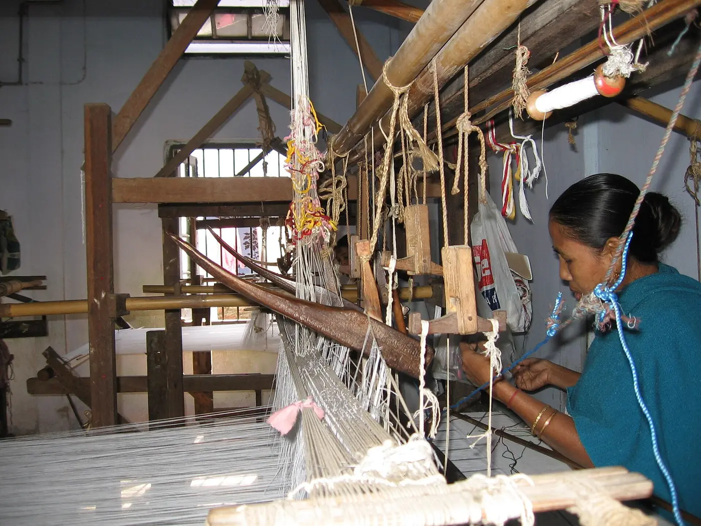 A weaver working at a traditional handloom in Assam